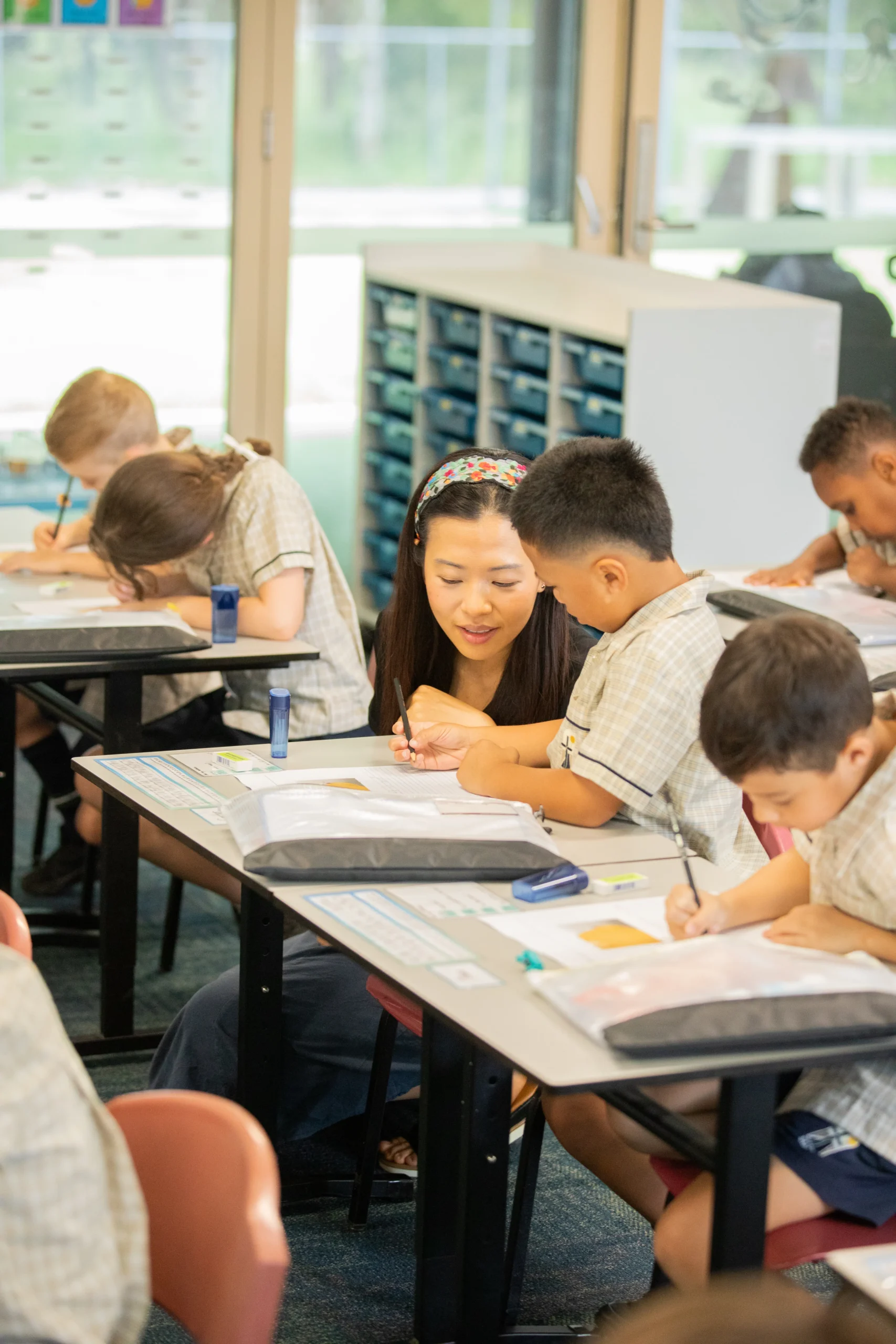 Teen sitting in a chair at a ceremony smiling at his friend.